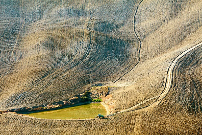 Irrigation pond with tractor in dry land down the hill. Irrigation pond with tractor in dry land down the hill