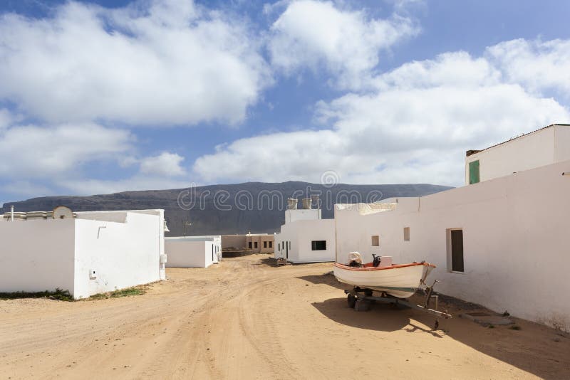Пустая улица с песком и Белые Дома в Caleta de Sebo на Ла Graciosa острова стоковые изображения rf Пустая улица с песком и Белые Дома в Caleta de Sebo на Ла Graciosa острова стоковые изображения rf