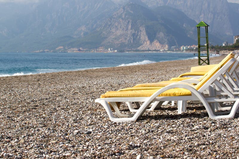 Пустые шезлонги на пляже около открытого моря, Kemer, Турции, Средиземного моря стоковые фотографии rf Пустые шезлонги на пляже около открытого моря, Kemer, Турции, Средиземного моря стоковые фотографии rf