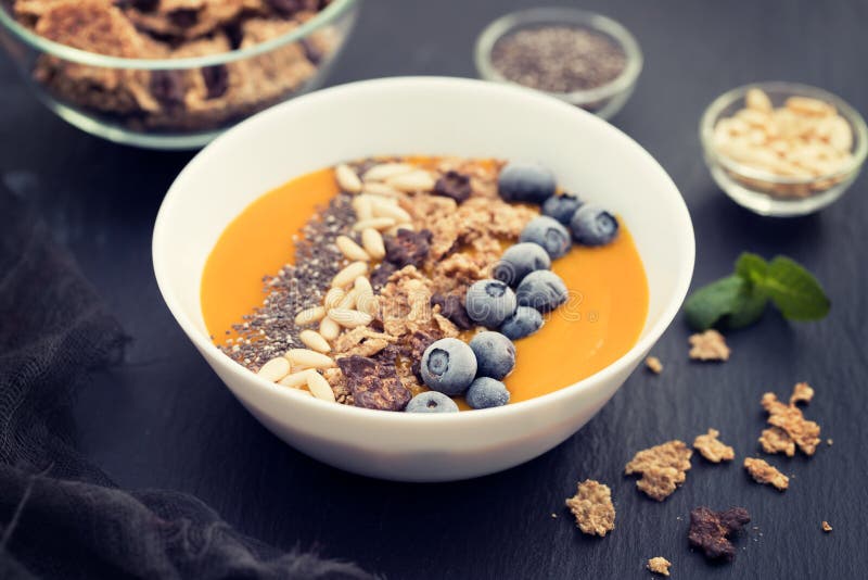 Пюре манго с granola, chia и ягодами в белом шаре стоковое изображение Пюре манго с granola, chia и ягодами в белом шаре стоковое изображение
