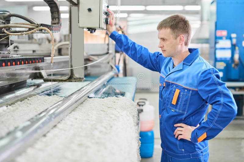 Работник прачечной в процессе работы на автоматической машине для стирки ковра стоковые фотографии rf Работник прачечной в процессе работы на автоматической машине для стирки ковра стоковые фотографии rf