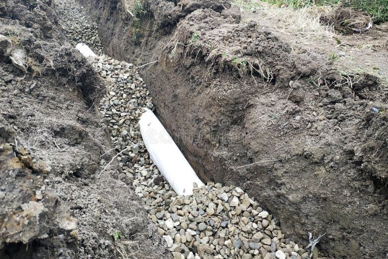 Работники уносят работы дренажа для того чтобы стечь воду вокруг дома стоковое фото Работники уносят работы дренажа для того чтобы стечь воду вокруг дома стоковое фото