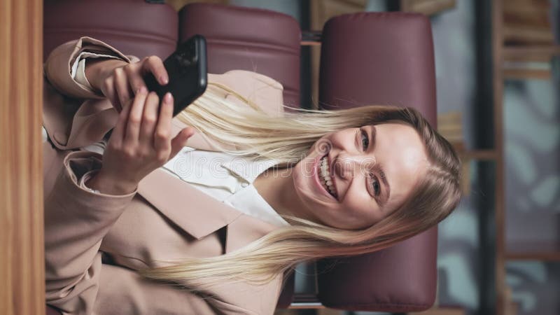 радостная блондинка пишет на смартфоне и улыбается сток-видео
