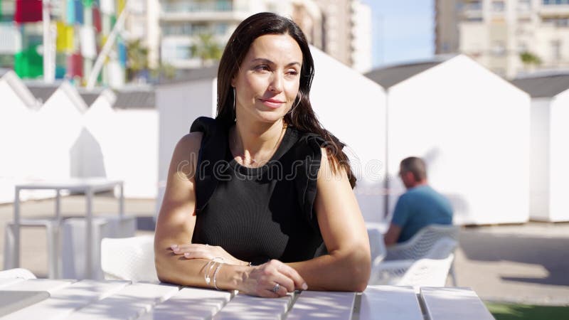 радостная женщина, сидящая за открытым столиком сток-видео