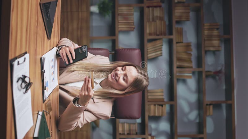 радостная леди делает дистанционный платеж на смартфоне в офисе акции видеоматериалы