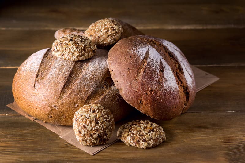 Разнообразие хлебцев свежего испеченного Rye и всего хлеба зерна на разнообразии фото деревянной предпосылки текстуры темном косм стоковое фото rf Разнообразие хлебцев свежего испеченного Rye и всего хлеба зерна на разнообразии фото деревянной предпосылки текстуры темном косм стоковое фото rf