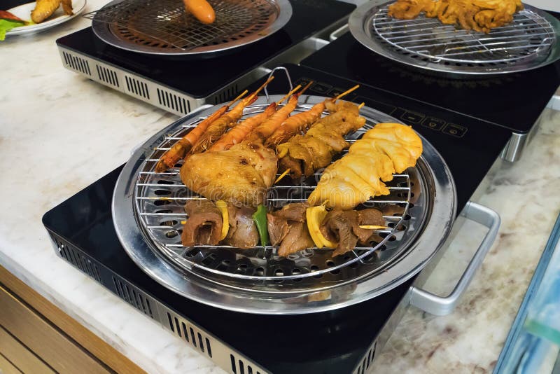 Разные виды kebabs зажарены на безопасном электрическом гриле в кухне ресторана Варить дома Зажаренная креветка, стоковое фото rf Разные виды kebabs зажарены на безопасном электрическом гриле в кухне ресторана Варить дома Зажаренная креветка, стоковое фото rf