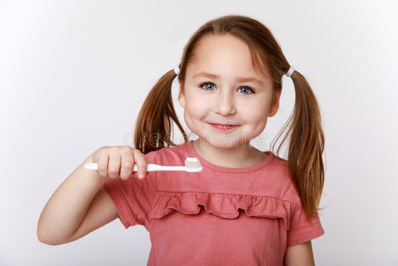 Smiling contented little girl while brushing teeth. Smiling contented little girl while brushing teeth