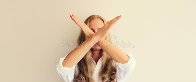 Upset young woman shows stop, no or enough sign with palm of hand, refusal gesture, domestic violence. Upset young woman shows stop, no or enough sign with palm of hand, refusal gesture, domestic violence