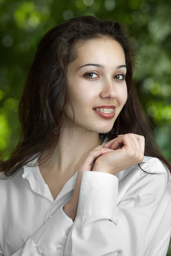 Model girl with braces on a background of trees. Model girl with braces on a background of trees