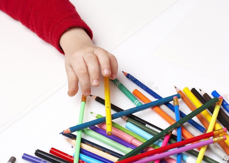 Ребенок выбирает карандаш для раскрашивания, много цветных карандашей стоковые фото