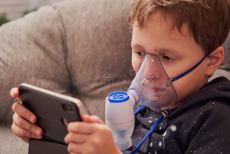 Ребенок делает nebulizer вдыхания дома на стороне носить nebulizer маски вдыхая пар распылил лекарство в легких стоковые фотографии rf Ребенок делает nebulizer вдыхания дома на стороне носить nebulizer маски вдыхая пар распылил лекарство в легких стоковые фотографии rf