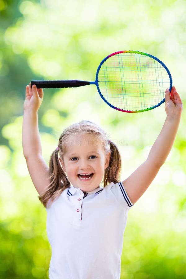 Active preschool girl playing badminton in outdoor court in summer. Kids play tennis. School sports for children. Racquet and shuttlecock sport for child athlete. Kid with racket and shuttle. Active preschool girl playing badminton in outdoor court in summer. Kids play tennis. School sports for children. Racquet and shuttlecock sport for child athlete. Kid with racket and shuttle.