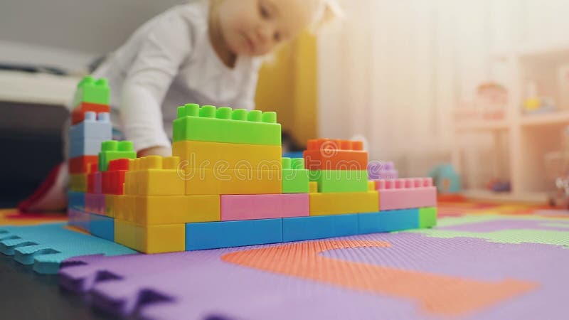 Ребенок играя со строительными блоками на поле видеоматериал