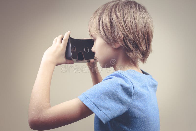 Ребенок используя новые стекла картона виртуальной реальности черноты 3D стоковые изображения rf Ребенок используя новые стекла картона виртуальной реальности черноты 3D стоковые изображения rf