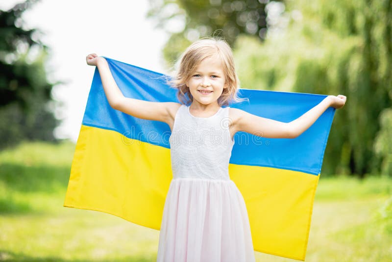 Ребенок носит порхать голубой и желтый флаг Украины в пшеничном поле Ukraine& x27; День независимости s День флага стоковое фото Ребенок носит порхать голубой и желтый флаг Украины в пшеничном поле Ukraine& x27; День независимости s День флага стоковое фото
