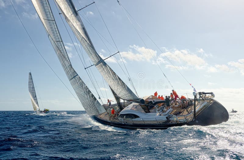 Two sailing yachts in a regatta under sail in the sea. Two sailing yachts in a regatta under sail in the sea