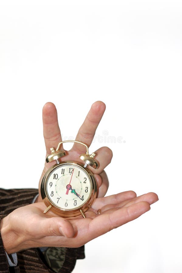 A man keeping an alarm clock in his palm. A man keeping an alarm clock in his palm