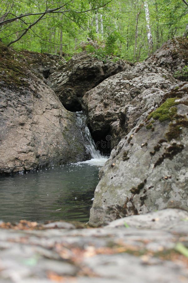 Река горы небольшой водопад на реке с кристально чистой водой, которая течет среди серых камней в лесу на стоковая фотография rf