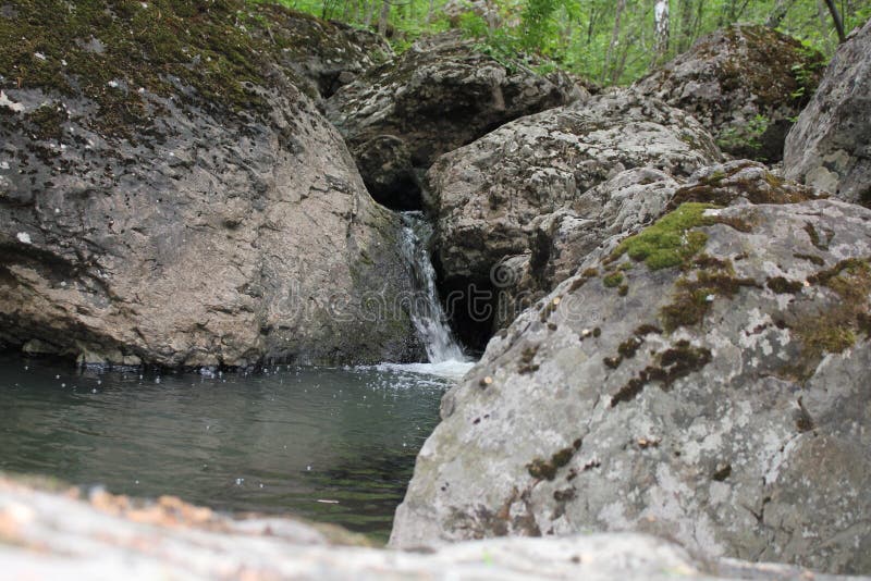 Река горы небольшой водопад на реке с кристально чистой водой, которая течет среди серых камней в лесу на стоковые изображения rf