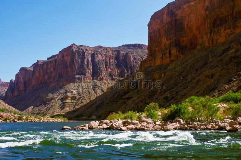 River rafters approach a rapid on the Colorado River in the Grand Canyon in Arizona on a sunny spring afternoon. River rafters approach a rapid on the Colorado River in the Grand Canyon in Arizona on a sunny spring afternoon