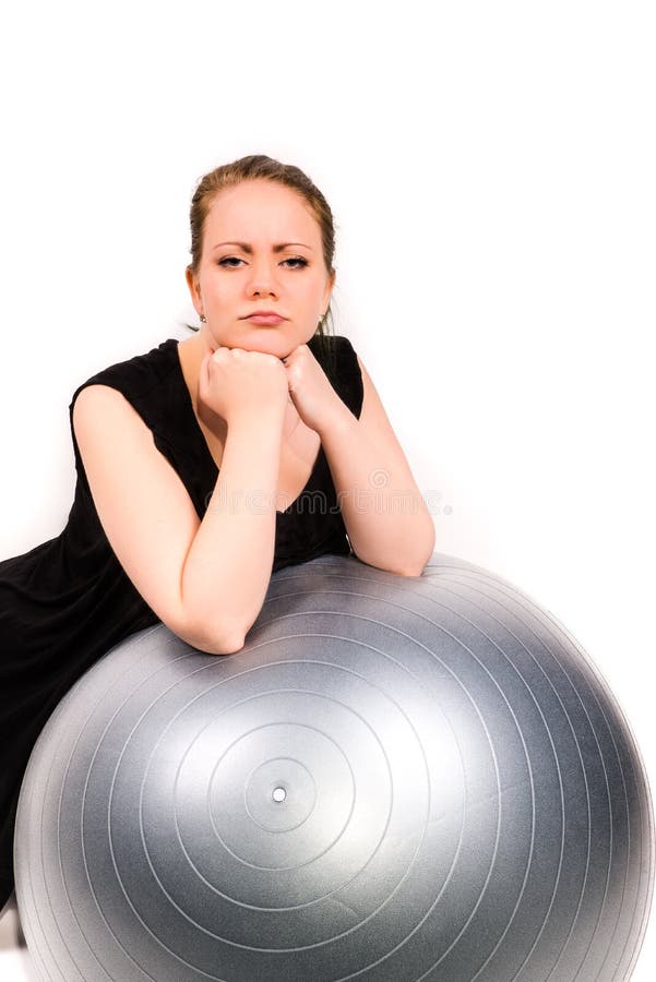 Решительно женщина полагаясь над шариком pilates стоковая фотография