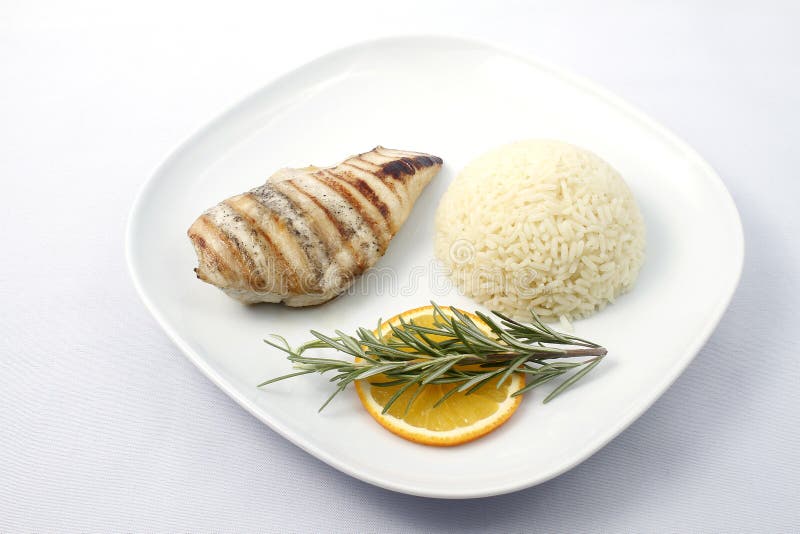 Grilled chicken breast with boiled rice on a white plate. Raw available. Grilled chicken breast with boiled rice on a white plate. Raw available.