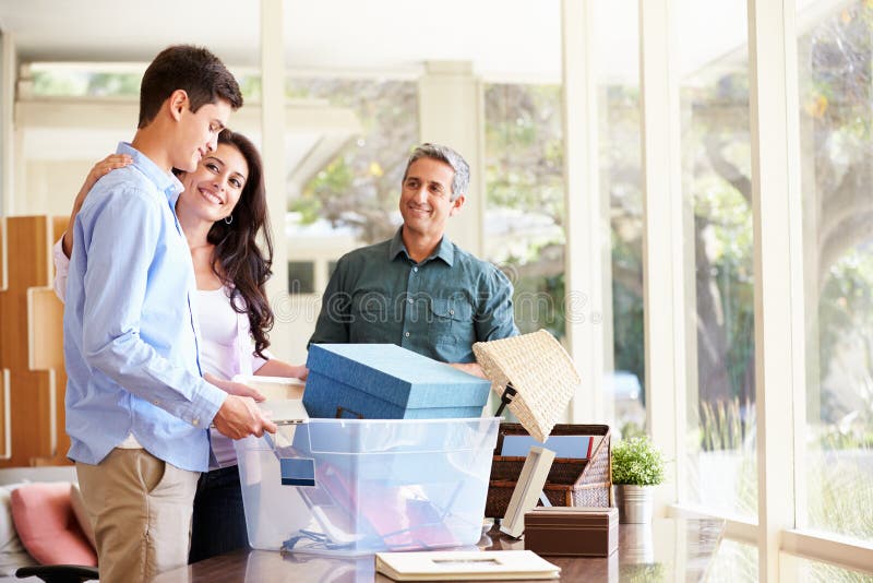 Parents Helping Teenage Son Pack For College At Home Smiling. Parents Helping Teenage Son Pack For College At Home Smiling