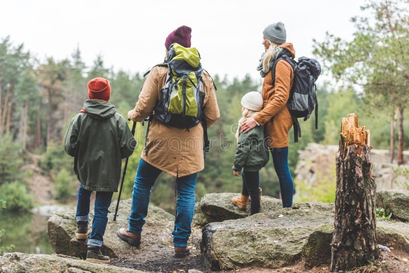 Родители и дети trekking в лесе стоковые фото