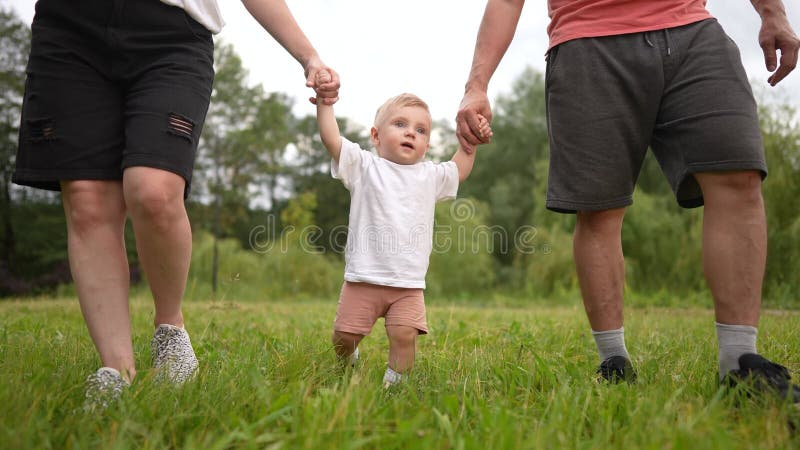 родители и ребенок гуляют в парке. концепция шага hug stroller. семья с ребенком на природе. родителей и их родителей акции видеоматериалы