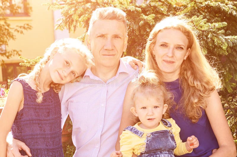Родители с 2 маленьких дочерей в парке. Портрет семьи. Образ жизни природы стоковые изображения