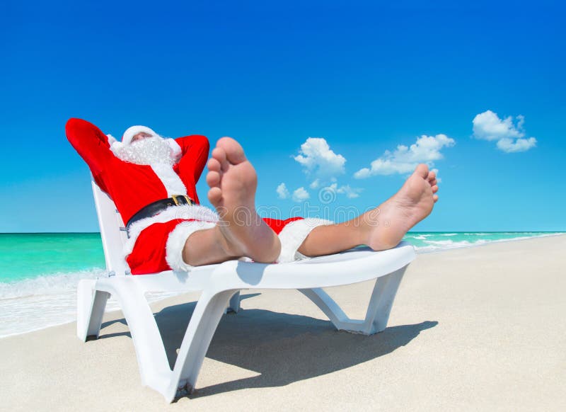 Рождество Санта Клаус загорает на sunlounger на тропическом океане b стоковое фото