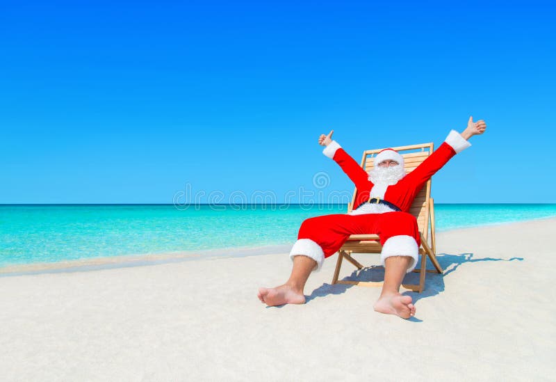 Рождество Санта Клаус на sunlounger удовлетворяемом с тропическим beac стоковое фото rf