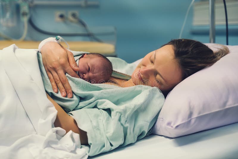 Рождение ребенка в родильном доме. Матери и новорожденного. Молодая мама обнимает ее новорожденного ребенка после родов. Женщины р стоковое фото