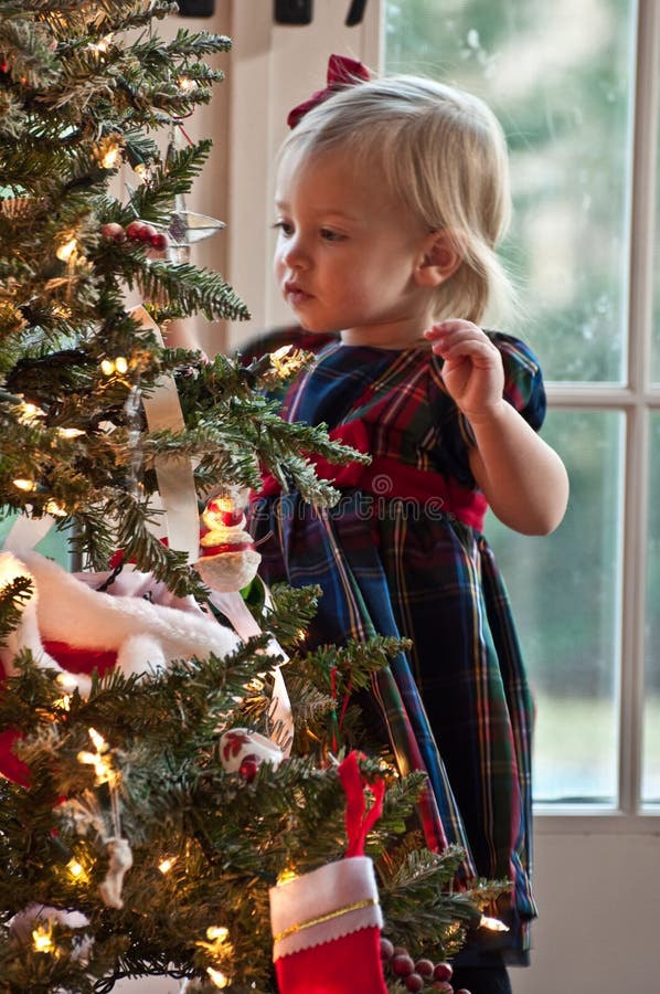 Little Girl Decorating A Christmas Tree. Little Girl Decorating A Christmas Tree