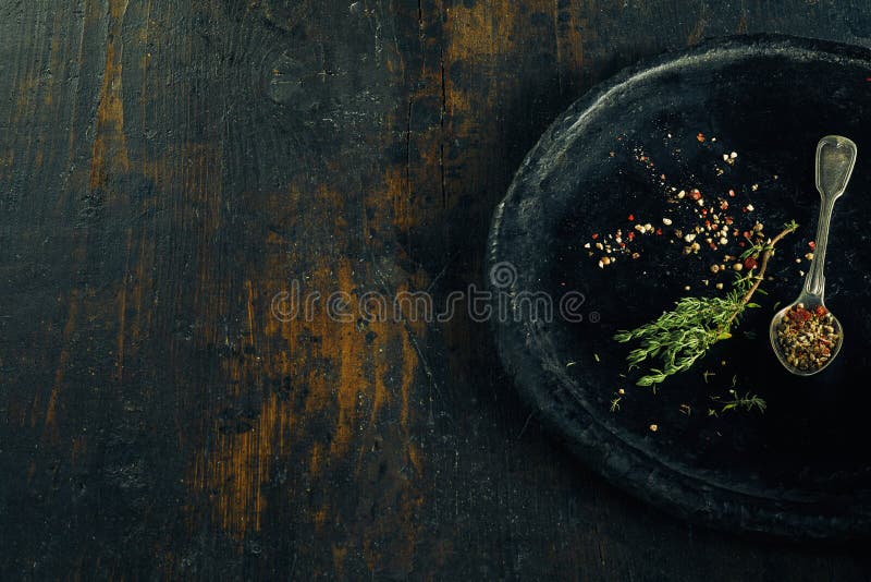 Rosemary, herbs and seasoning in a stone bowl on a rustic timber bench with copy space. Rosemary, herbs and seasoning in a stone bowl on a rustic timber bench with copy space.