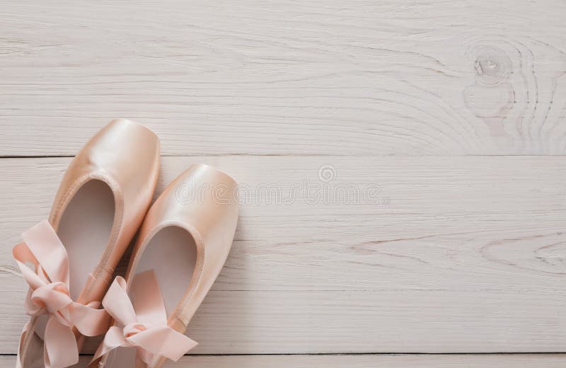 Розовые ботинки pointe балета на белой деревянной предпосылке стоковые изображения rf Розовые ботинки pointe балета на белой деревянной предпосылке стоковые изображения rf
