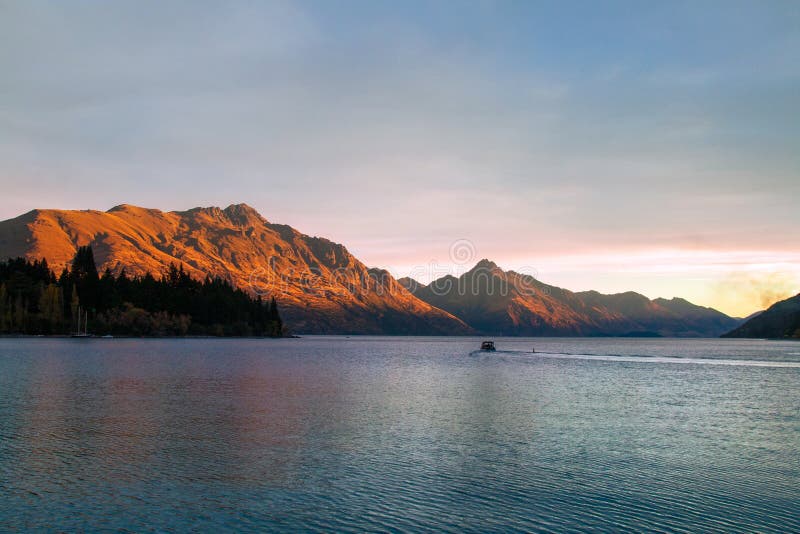 Романтичный заход солнца на озере Wakatipu, золотое отражение солнца на Вальтер и пик Сесиль, Queenstown Новая Зеландия стоковые изображения rf Романтичный заход солнца на озере Wakatipu, золотое отражение солнца на Вальтер и пик Сесиль, Queenstown Новая Зеландия стоковые изображения rf