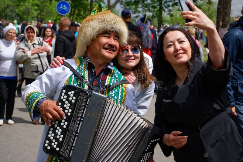Россия, Магнитогорск, - 15-ое июня 2019 Девушки принимают selfie с аккордеоном в фольклорном костюме во время Sabantuy - национал стоковое изображение rf Россия, Магнитогорск, - 15-ое июня 2019 Девушки принимают selfie с аккордеоном в фольклорном костюме во время Sabantuy - национал стоковое изображение rf