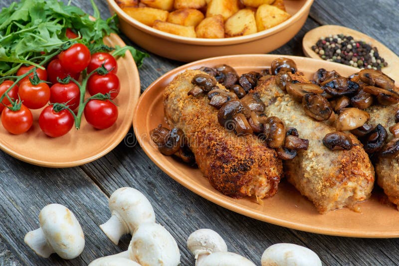 Рулада свинины с зажаренными в духовке грибами и картошками стоковая фотография Рулада свинины с зажаренными в духовке грибами и картошками стоковая фотография