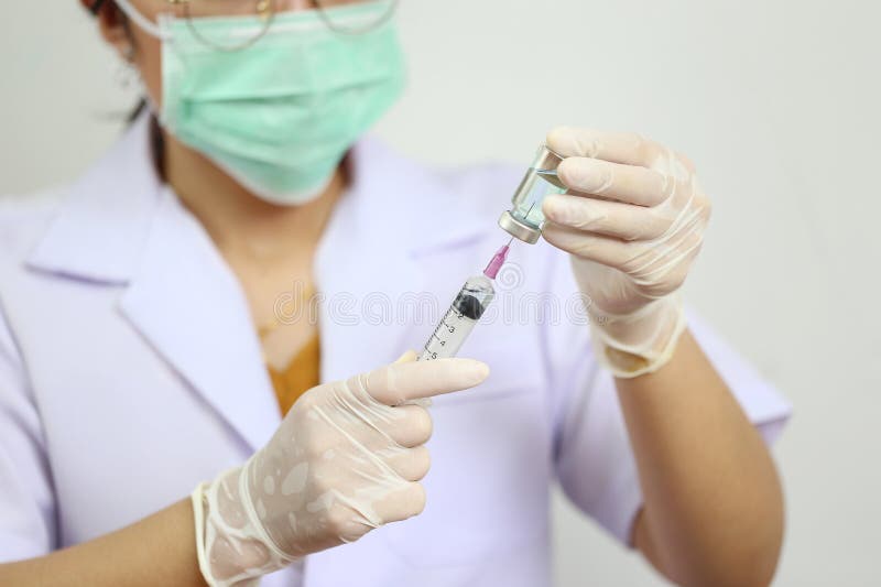 Рука доктора держа шприц притяжки и бутылку медицины на белой предпосылке, концепции медицины стоковые изображения rf Рука доктора держа шприц притяжки и бутылку медицины на белой предпосылке, концепции медицины стоковые изображения rf