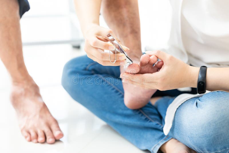 Рука дочери держит клипер ногтя, режа toenails для ее матери, азиатская помощь молодой женщины для того чтобы отрезать toenails д стоковые изображения Рука дочери держит клипер ногтя, режа toenails для ее матери, азиатская помощь молодой женщины для того чтобы отрезать toenails д стоковые изображения