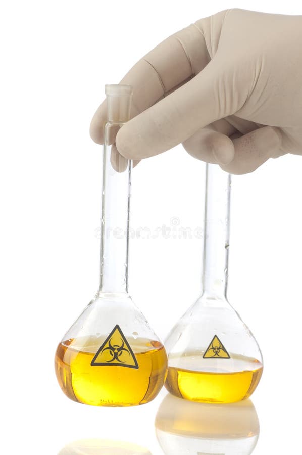 Рука держит стеклянную медицинскую трубку с желтым biohazard жидкости и символа. стоковые изображения rf Рука держит стеклянную медицинскую трубку с желтым biohazard жидкости и символа. стоковые изображения rf