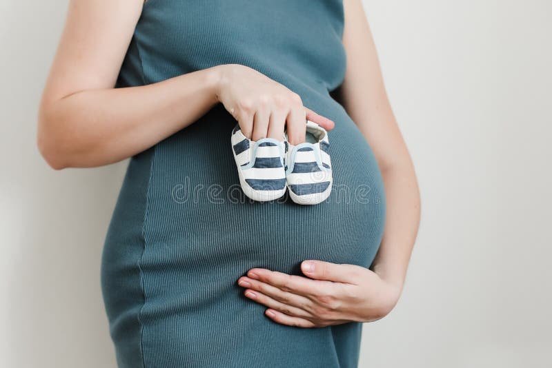 Руки матери держа ботинки для newborn младенца Беременная женщина касаясь животу Счастливая беременность женщины, материнство, за стоковые изображения rf Руки матери держа ботинки для newborn младенца Беременная женщина касаясь животу Счастливая беременность женщины, материнство, за стоковые изображения rf