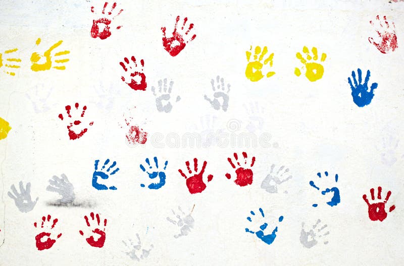 Graffiti with multiple colored hand prints on the white wall background. Graffiti with multiple colored hand prints on the white wall background.