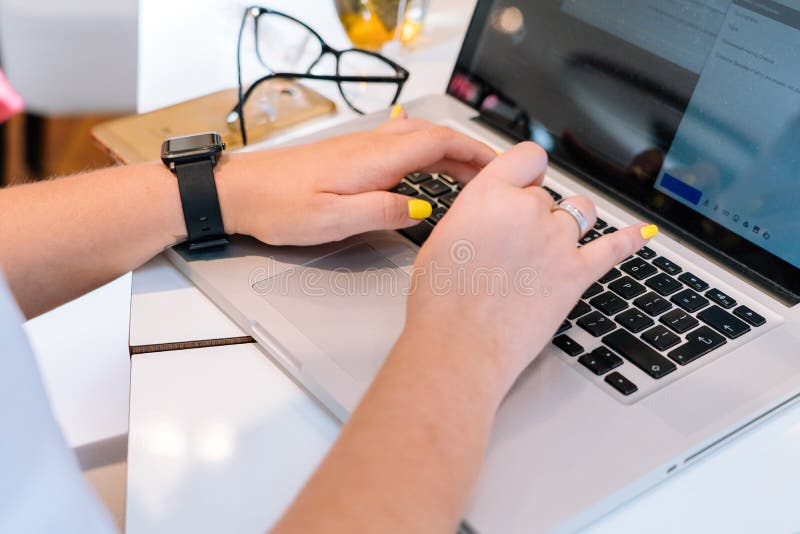 Руки непознаваемой женщины сидя в офисе coworking и печатая на ее компьютере клавиатуры ноутбука стоковая фотография Руки непознаваемой женщины сидя в офисе coworking и печатая на ее компьютере клавиатуры ноутбука стоковая фотография