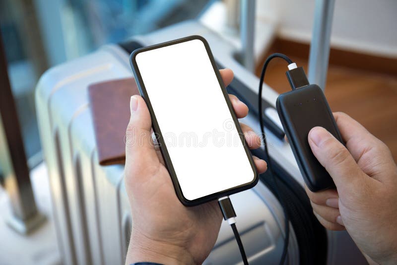 Руки человека, держащего телефон с изолированными экраном и чемодан powerbank стоковые фото