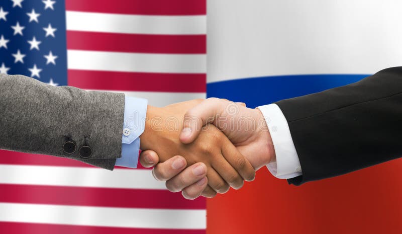 Рукопожатие над флагами американских и русского стоковое фото Рукопожатие над флагами американских и русского стоковое фото