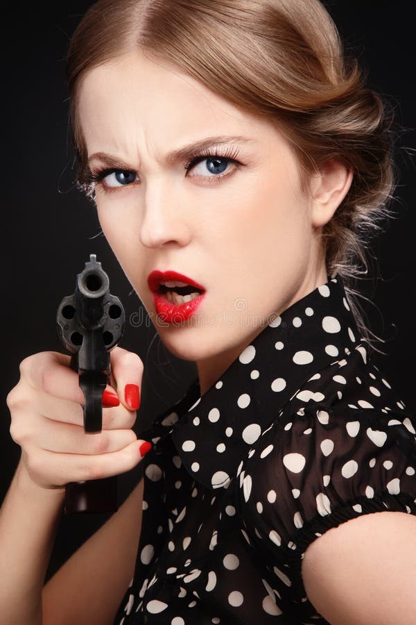 Emotional portrait of beautiful young angry blond woman with revolver in hand. Emotional portrait of beautiful young angry blond woman with revolver in hand