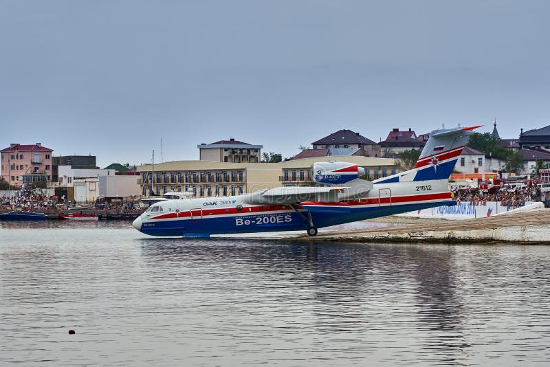 Русское универсальное воздушное судно Beriev Be-200ES лодкамиамфибии собирает воду и подготавливает принять от ровной поверхности стоковая фотография Русское универсальное воздушное судно Beriev Be-200ES лодкамиамфибии собирает воду и подготавливает принять от ровной поверхности стоковая фотография